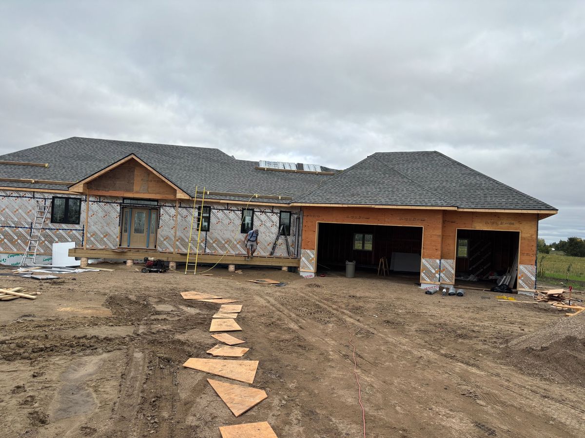 New construction custom home front view with nearly completed roof