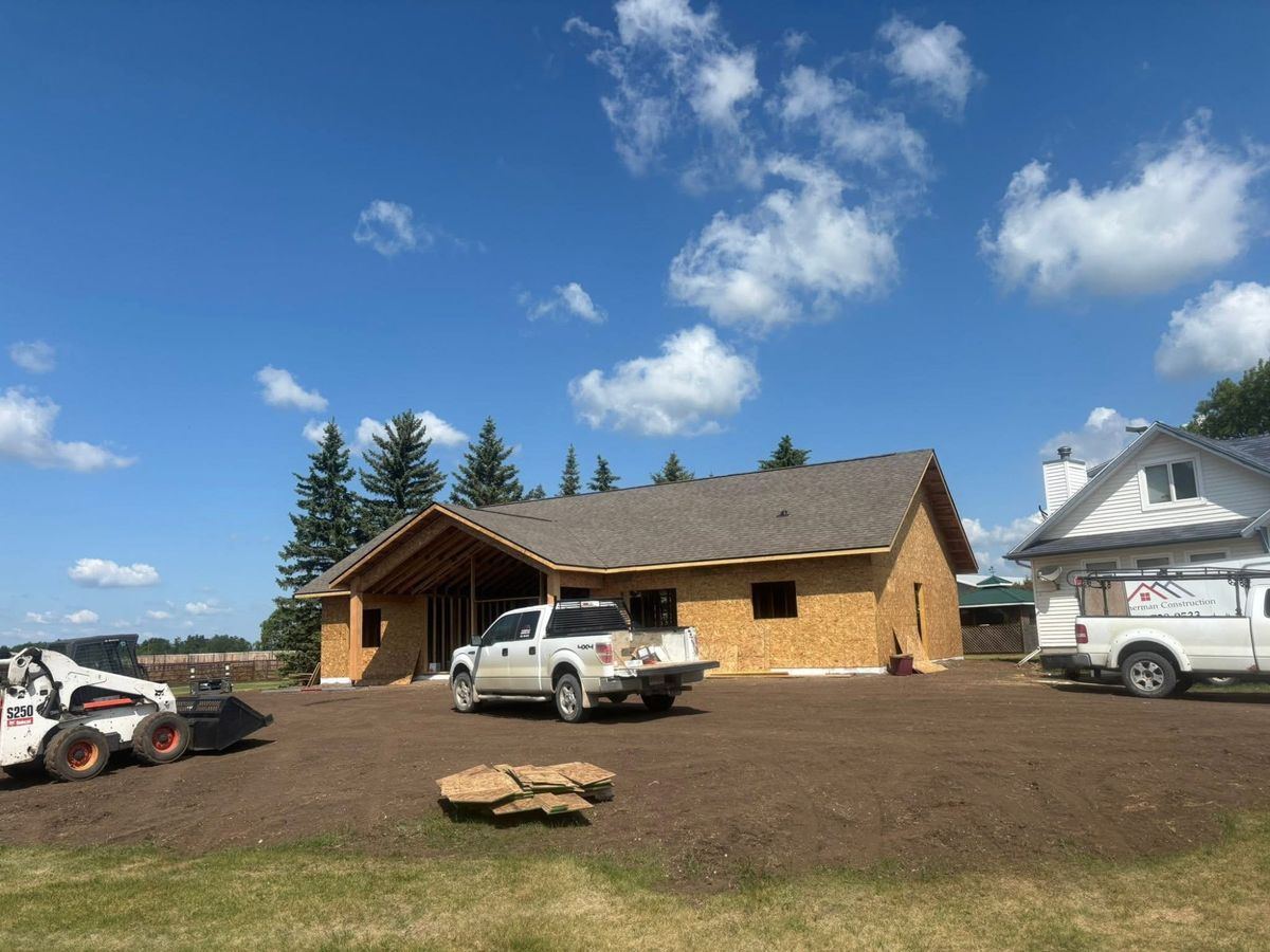New construction roofing project with trucks and blue prairie sky