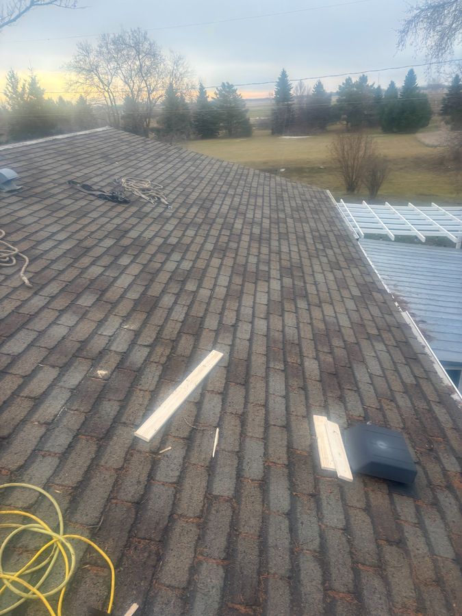 Old worn 3-tab shingles before metal roof replacement