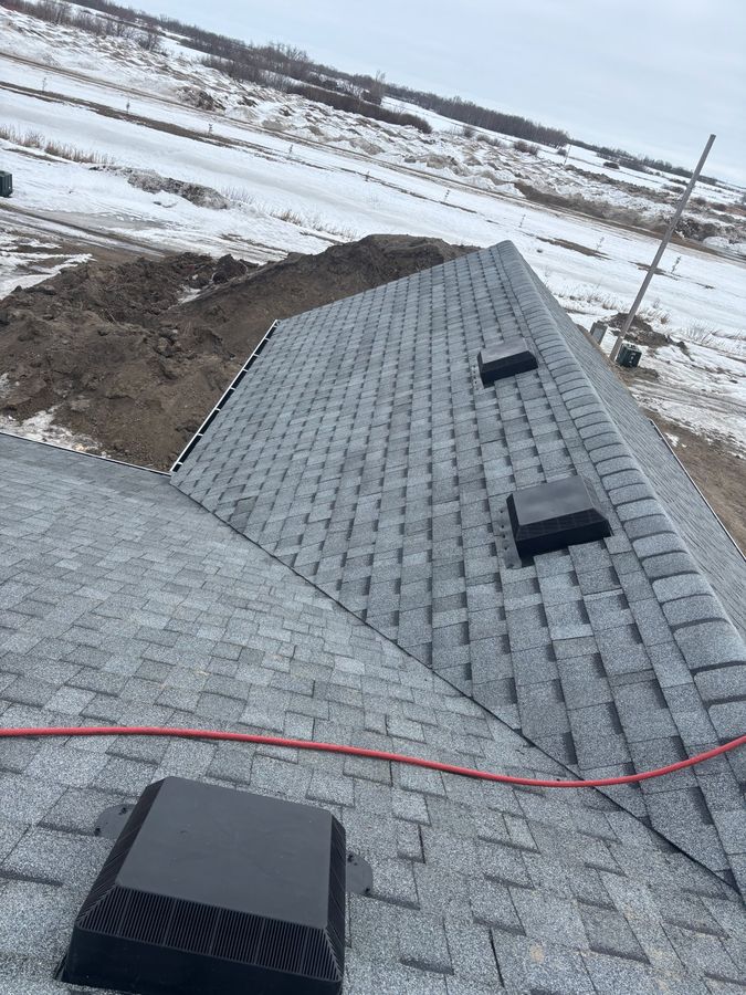 Winter new construction roofing with snowy prairie